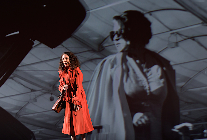 »Médée«, 1. Akt: Rosa Feola (Dircé) erhofft sich Amors Beistand, während im Hintergrund eines von Simon Stones Filmchen abläuft. © Salzburger Festspiele/Thomas Aurin